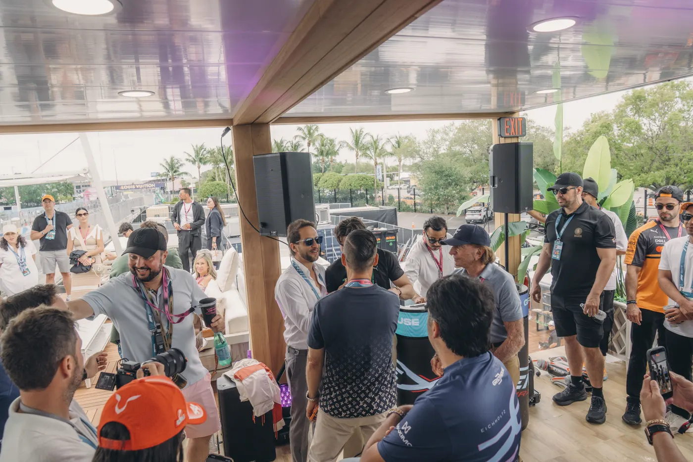 Invitados en la baranda mientras los autos pasan por el circuito de Miami