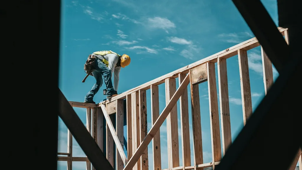 Obrero sobre la estructura de madera de una casa en construcción